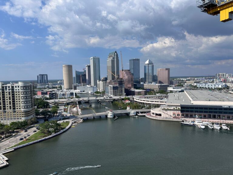 Stunning aerial view of downtown Tampa's skyline along the waterfront under a bright daytime sky.